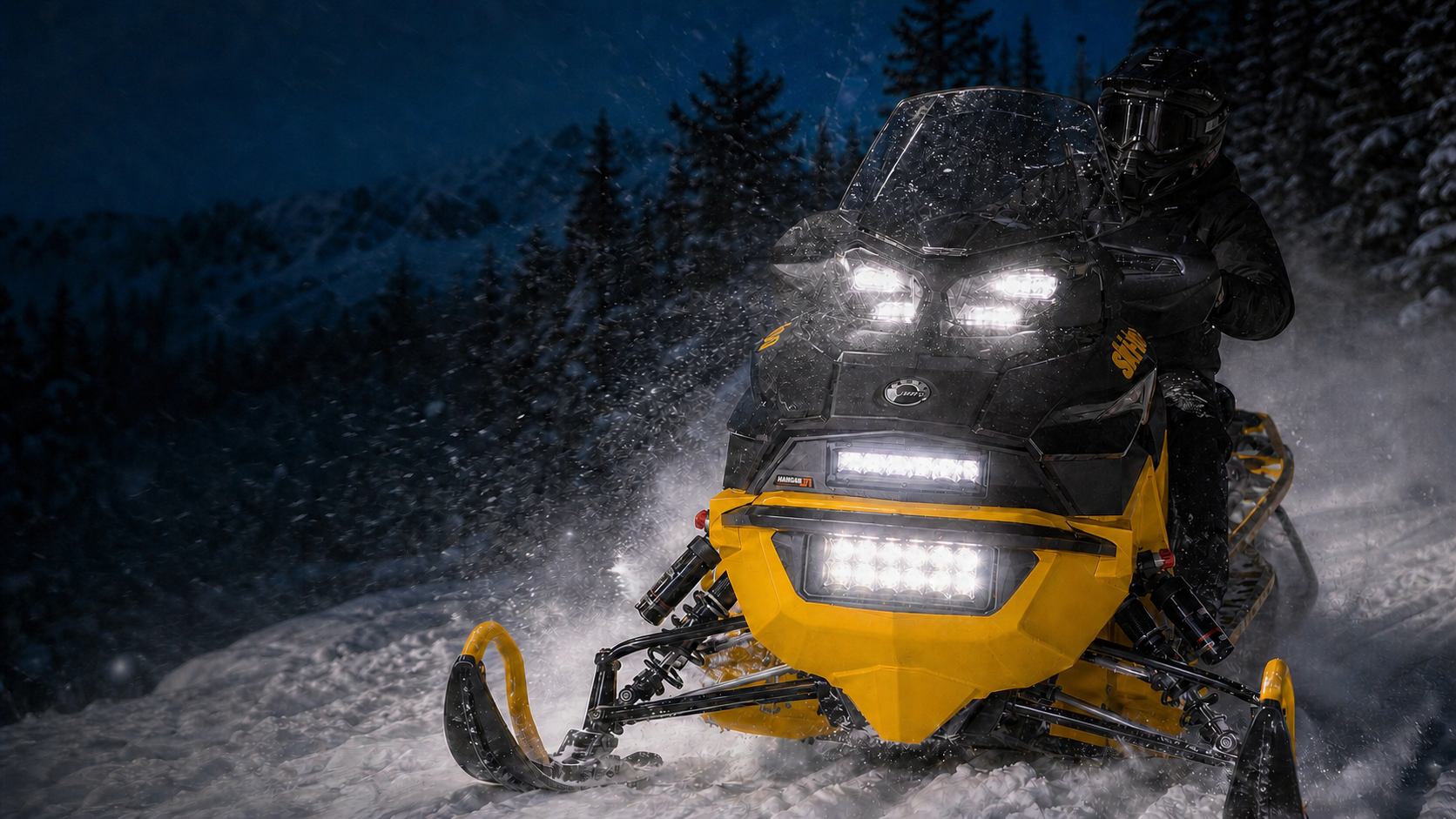 Yellow snowmobile riding at night with its headlights and two auxiliary lights illuminated